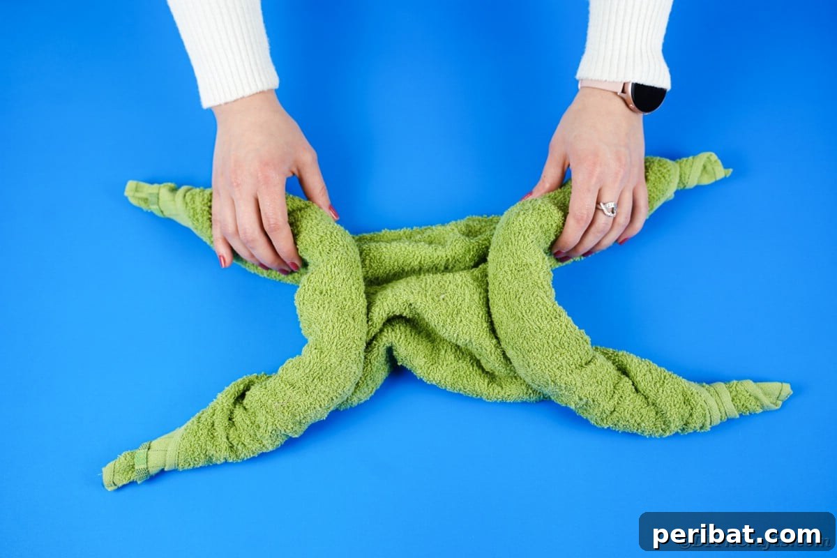 Towel Origami: Animal Edition 13 Twisting a green towel to form the turtle's leg shape