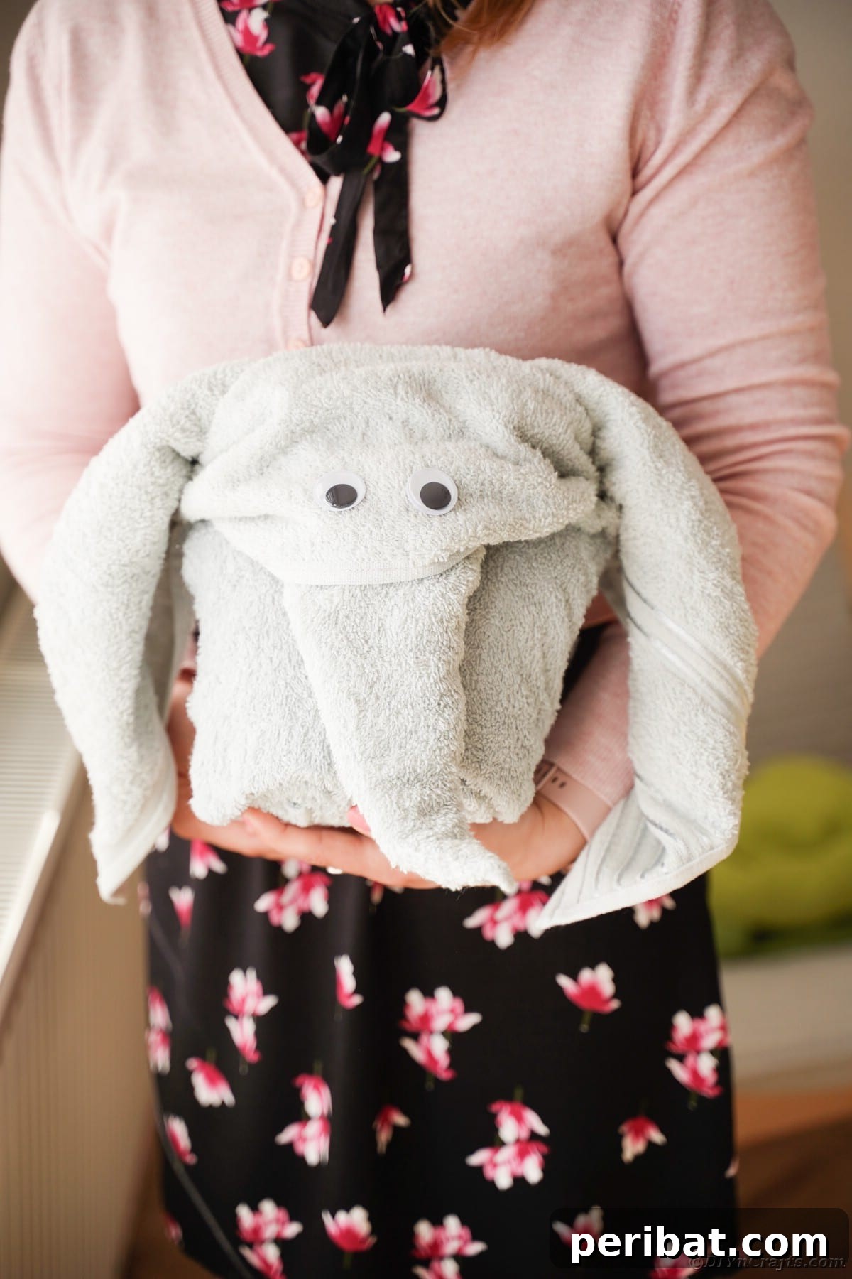 Towel Origami: Animal Edition 16 Woman holding a grey elephant towel, a perfect gift idea