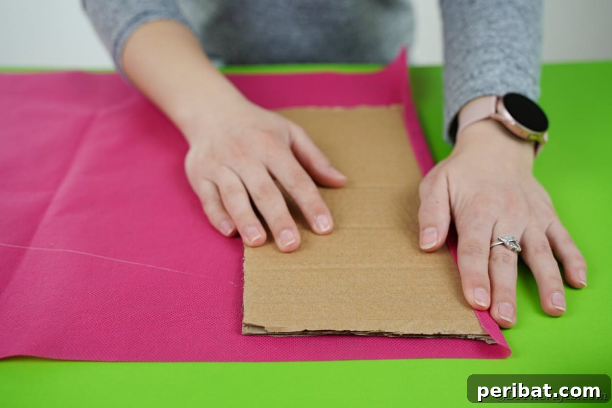 Create a Charming Diaper Train for Baby Shower Joy 12 Tissue paper being glued onto a piece of cardboard, preparing the platform for the diaper cake train's structure.
