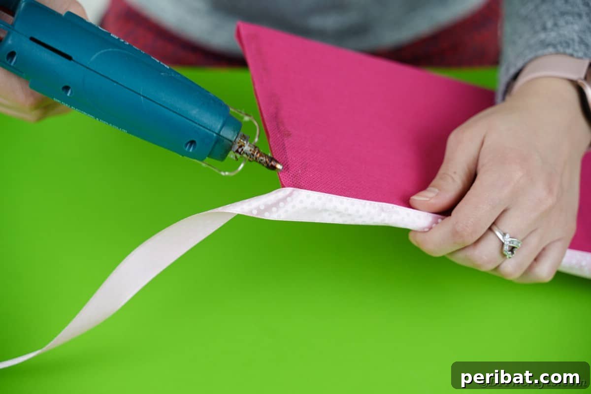 Create a Charming Diaper Train for Baby Shower Joy 14 A delicate ribbon being glued around the edge of a tissue-paper-wrapped cardboard, adding a finishing touch to the platform.