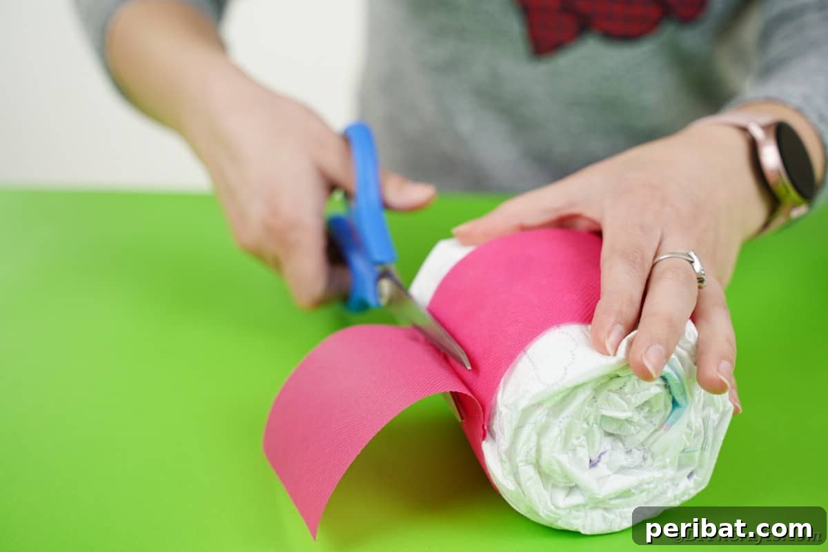 Create a Charming Diaper Train for Baby Shower Joy 20 A roll of three diapers being wrapped with tissue paper, secured with tape or glue to form another train component.