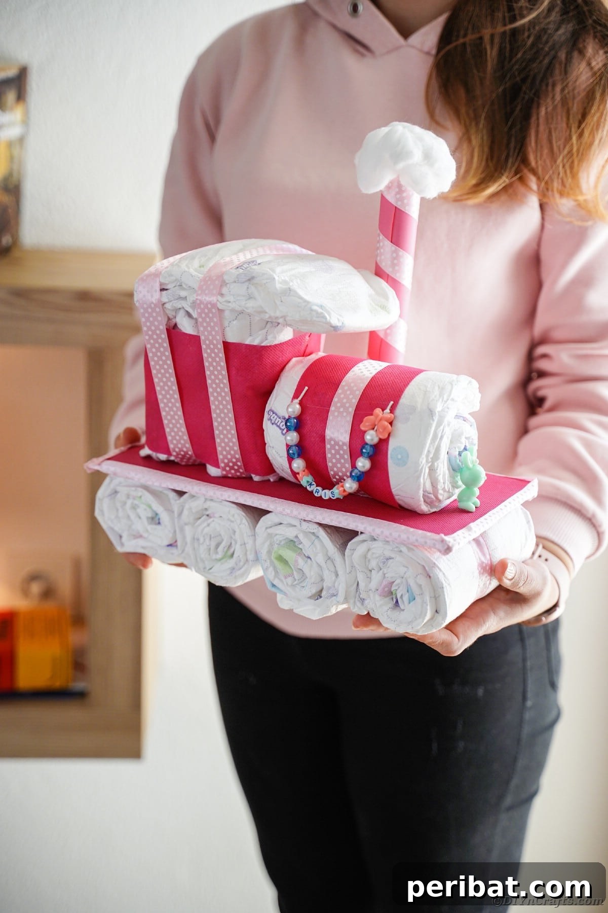Create a Charming Diaper Train for Baby Shower Joy 28 A woman presenting the finished diaper cake train, highlighting its impressive size and detailed craftsmanship.