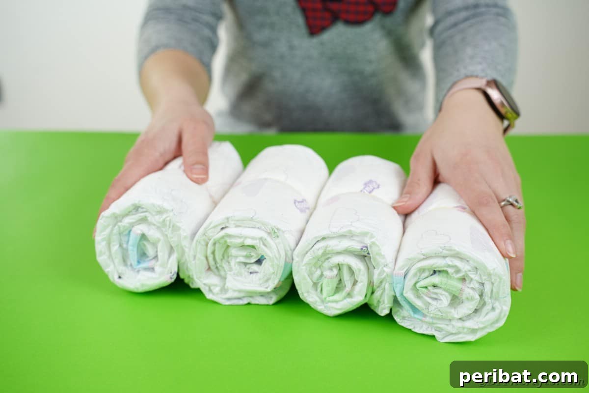 Create a Charming Diaper Train for Baby Shower Joy 10 A stack of perfectly rolled diaper bundles, each secured with a rubber band, ready for assembly into the train's body.