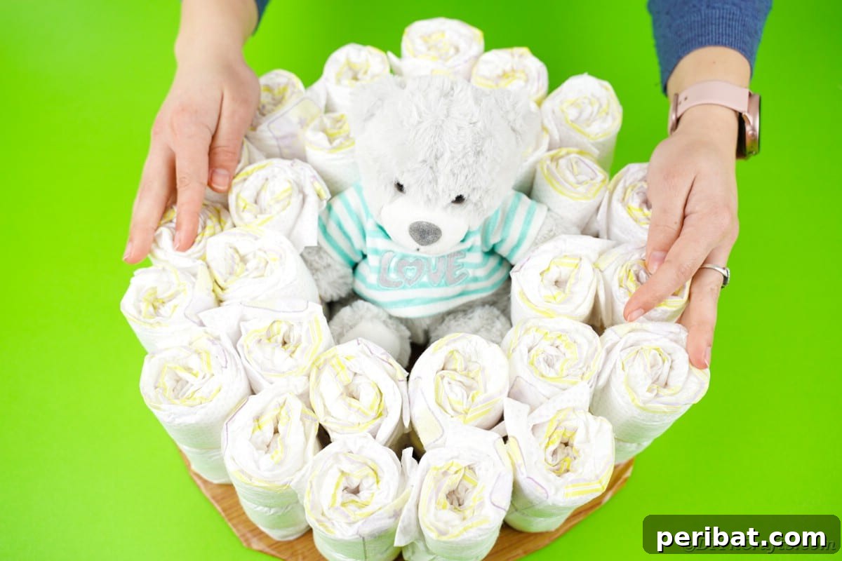 Rolled diapers neatly arranged in a circle around a teddy bear on the base, forming the body of the diaper cake.