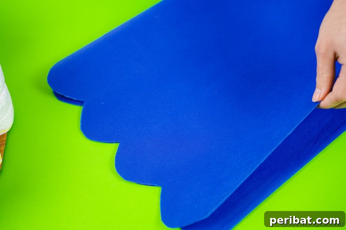 Scalloped blue tissue paper, meticulously cut and folded, ready to wrap around the diaper cake like a candy wrapper.
