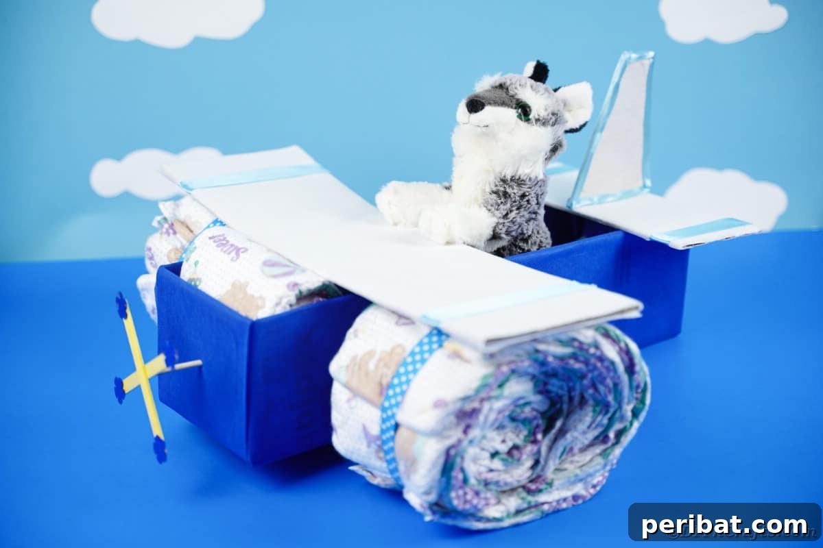 Cloud Nine Diaper Plane Baby Shower Gift 6 Diaper cake in front of cloud paper