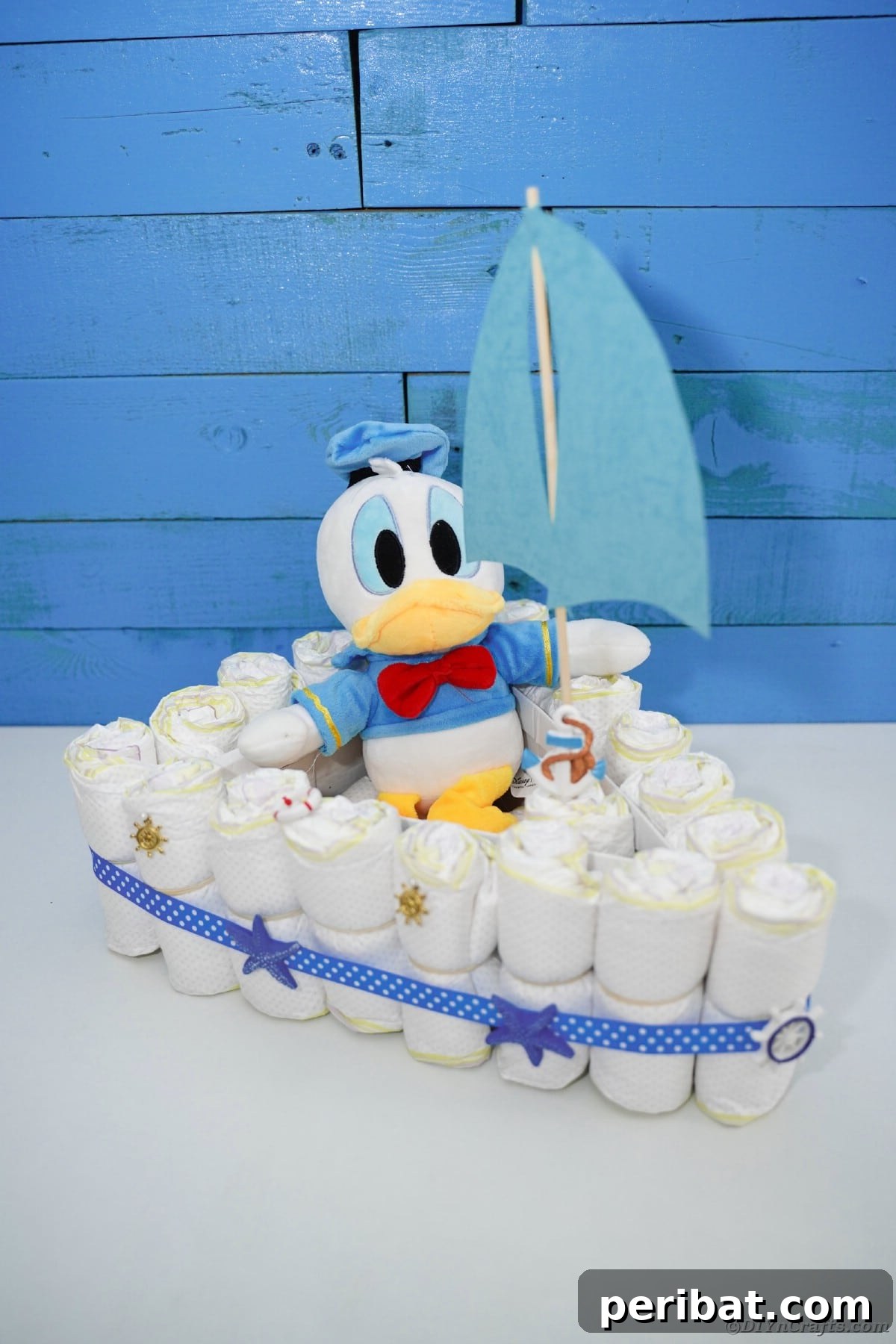 Diaper cake boat in front of blue boards