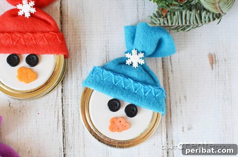 A collection of cute snowman ornaments made from mason jar lids, featuring painted faces, small fabric hats, and cheerful winter expressions.