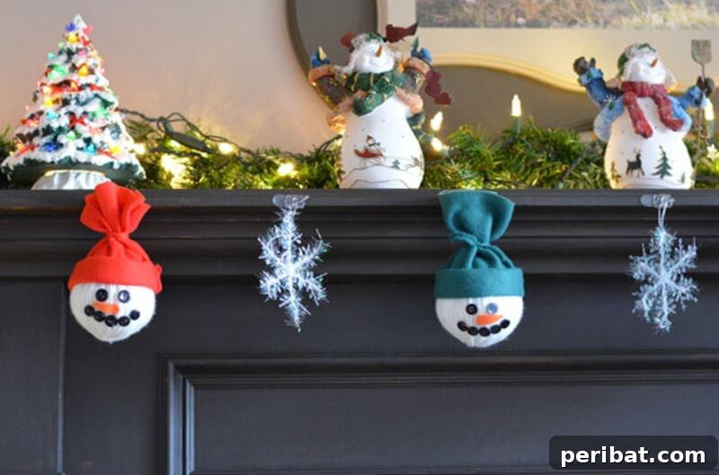 A festive mantle decorated with a garland of white yarn ball snowmen, each with tiny faces and scarves, adding a cozy touch to winter decor.