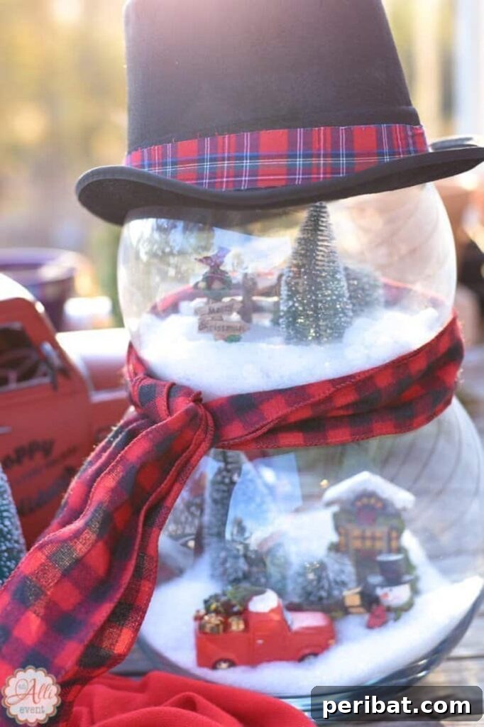 A charming 'Frosty the Snowman' decor piece created by stacking two fish bowls, filled with artificial snow and miniature winter scenes, adorned with a top hat.