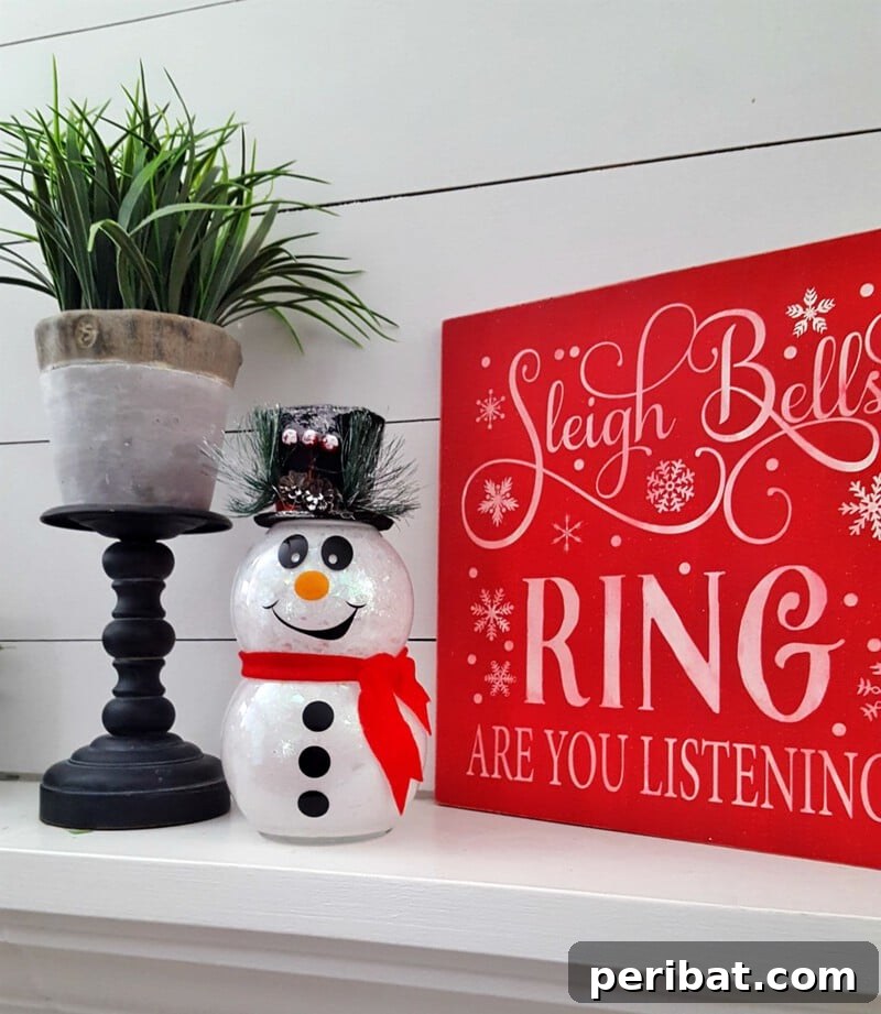 A dazzling DIY glitter snowman with internal lights, glowing softly on a mantle, adding a festive and magical ambiance to holiday decor.