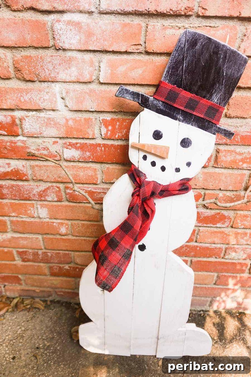 A rustic DIY wooden snowman sign, painted white with charming snowman features and a small scarf, leaning against a brick wall, perfect for outdoor winter decor.