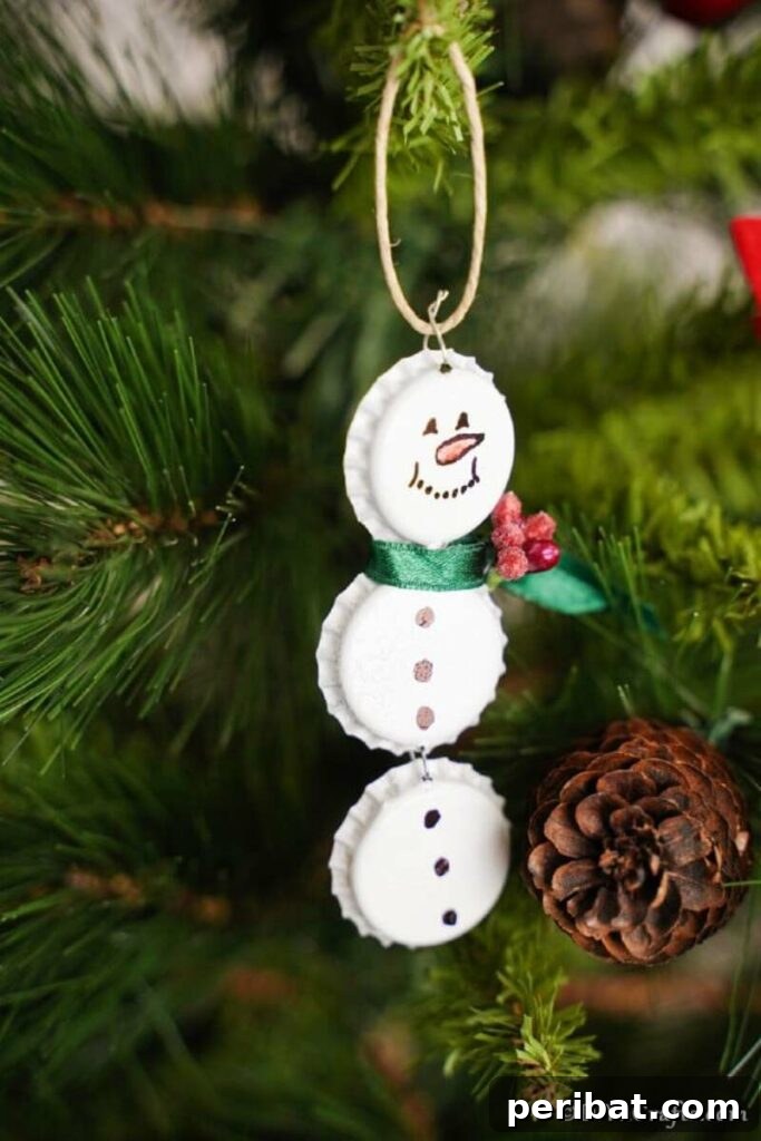 Three cheerful bottle cap snowman ornaments hanging, each with painted white faces, drawn features, and tiny fabric scarves, perfect for DIY Christmas decorations.