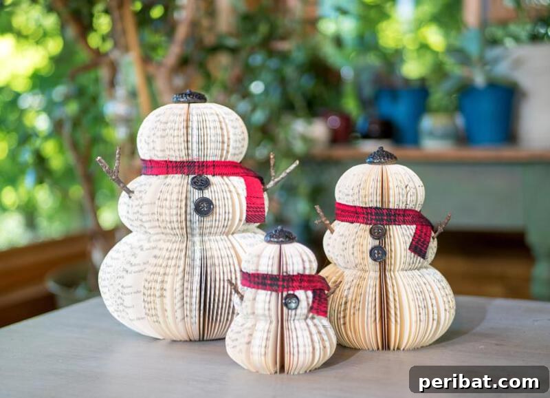 A creative upcycled snowman decoration made from an old book, with pages folded and shaped to form a snowman's body, adorned with a hat and scarf.
