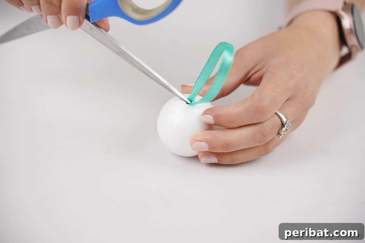 Craft Your Own Fluffy Pom Pom Christmas Ornaments 8 Adding ribbon to ball