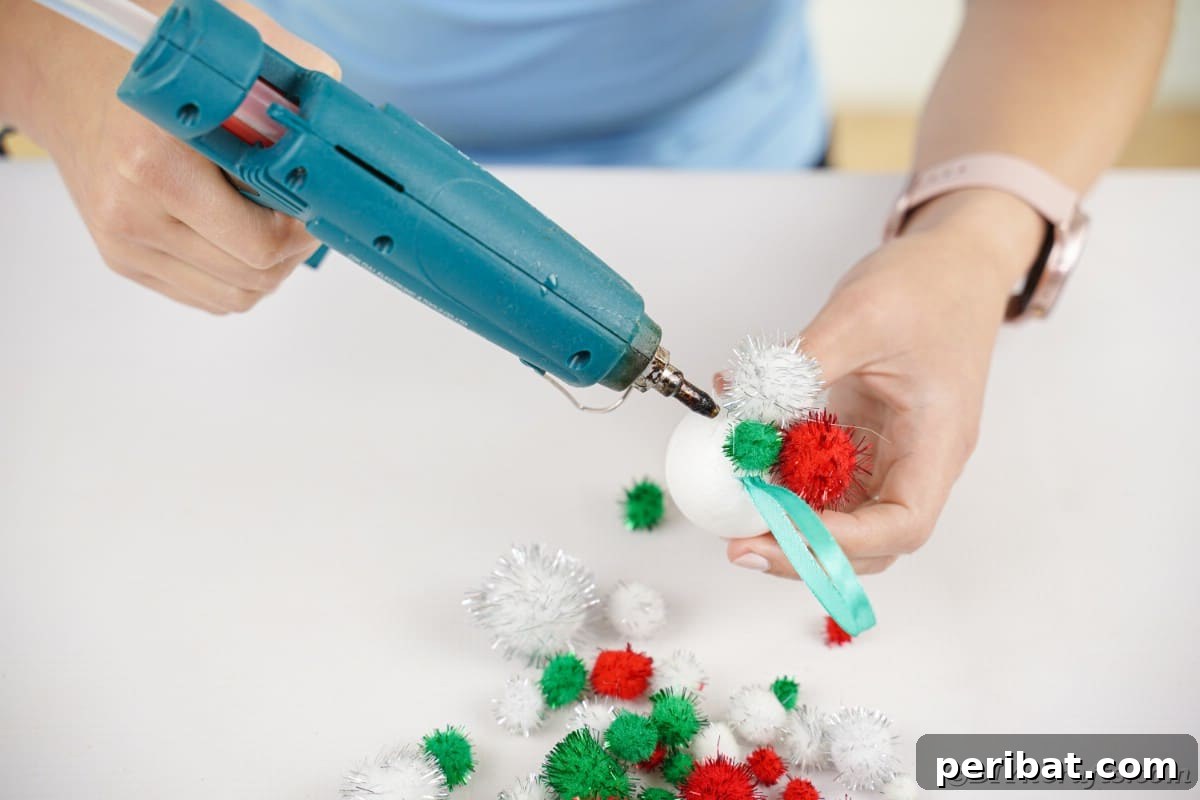 Craft Your Own Fluffy Pom Pom Christmas Ornaments 9 Gluing pom poms onto ball