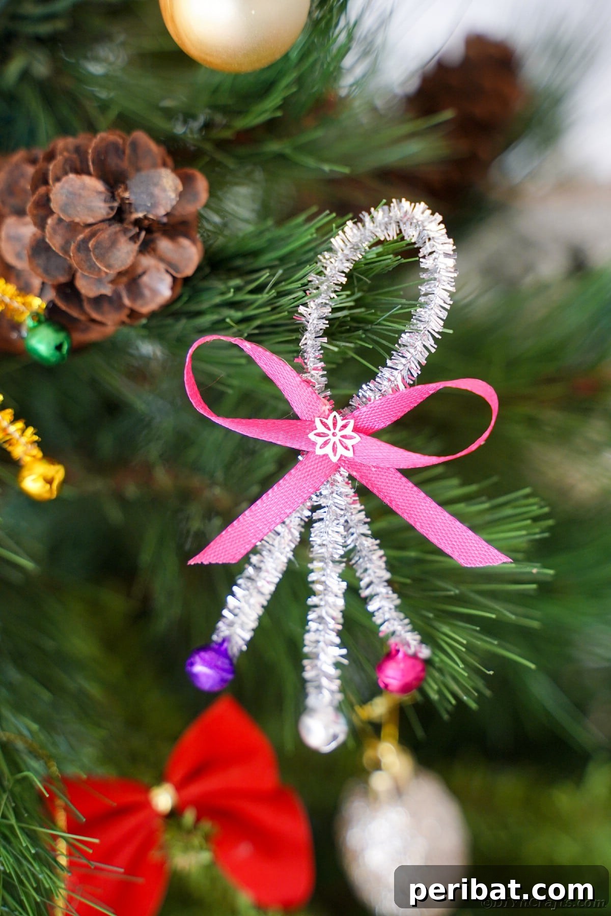 Whimsical Pipe Cleaner Jingle Bell Ornaments for Kids 12 Several finished pipe cleaner jingle bell ornaments hanging on a Christmas tree, sparkling brightly