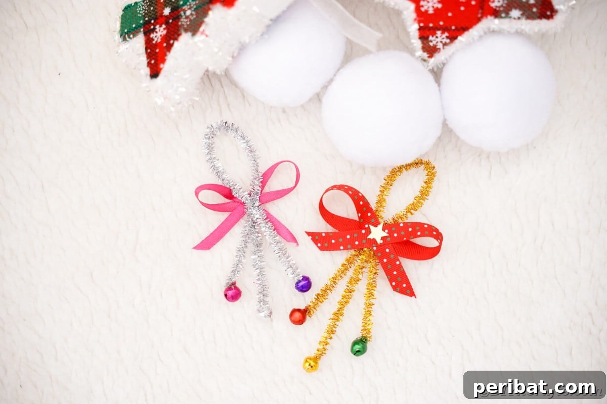 Whimsical Pipe Cleaner Jingle Bell Ornaments for Kids 3 A finished pipe cleaner jingle bell ornament resting on a white surface with pine branches