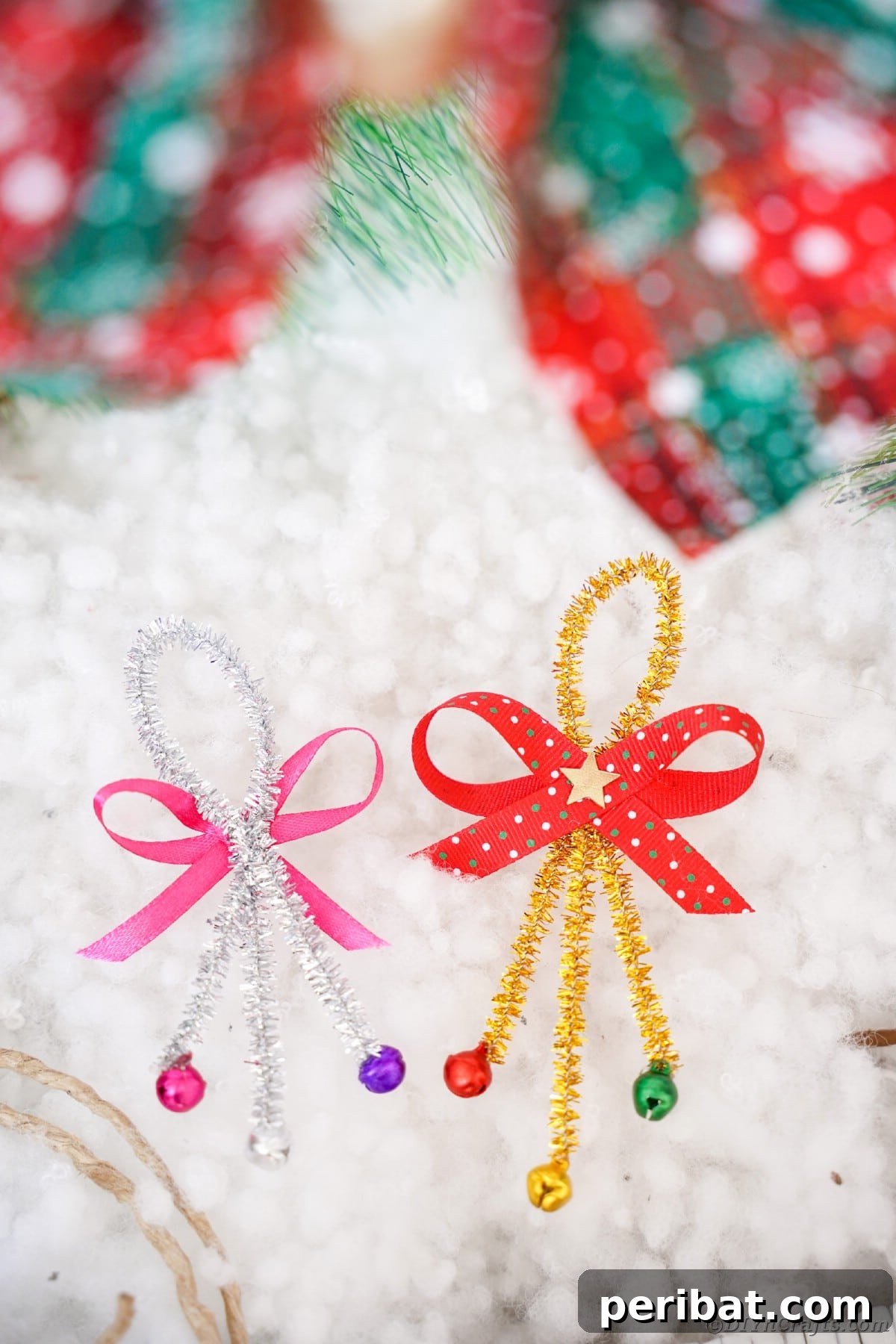Whimsical Pipe Cleaner Jingle Bell Ornaments for Kids 13 Several finished pipe cleaner jingle bell ornaments displayed on artificial snow with decorative greenery