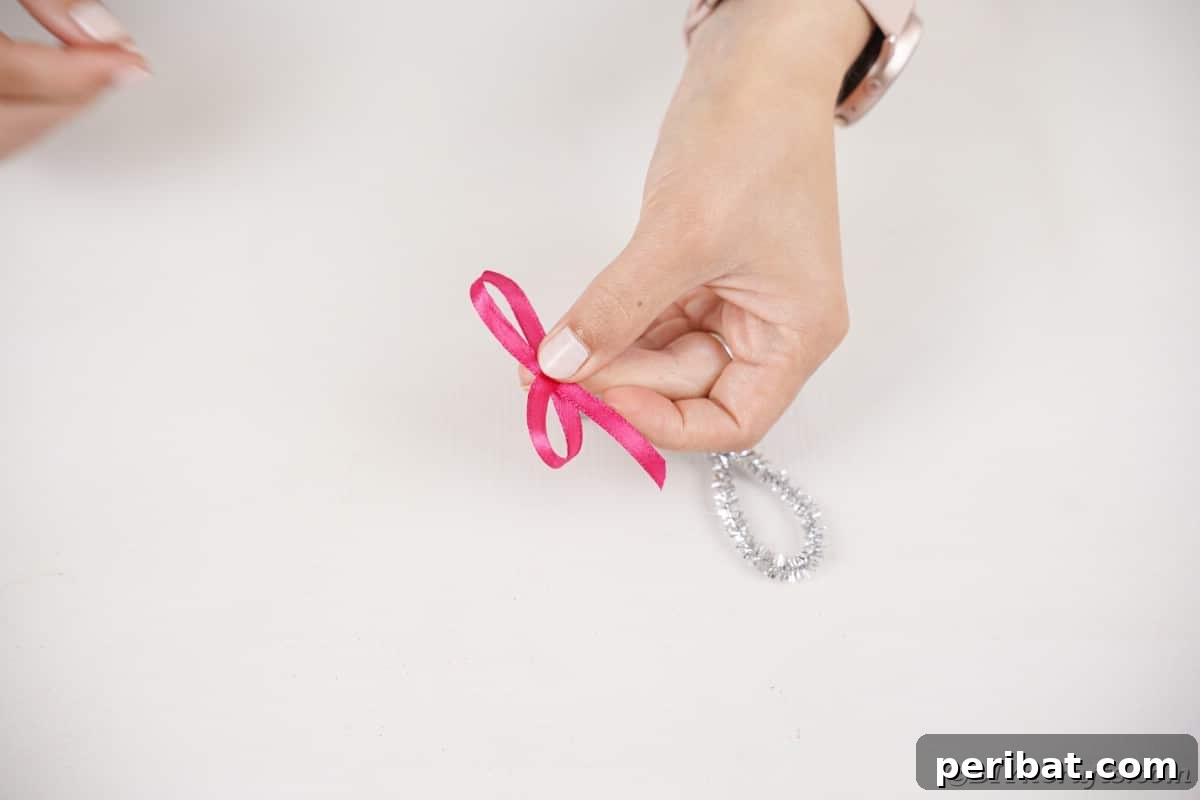Whimsical Pipe Cleaner Jingle Bell Ornaments for Kids 10 Hands tying a small red ribbon into a bow