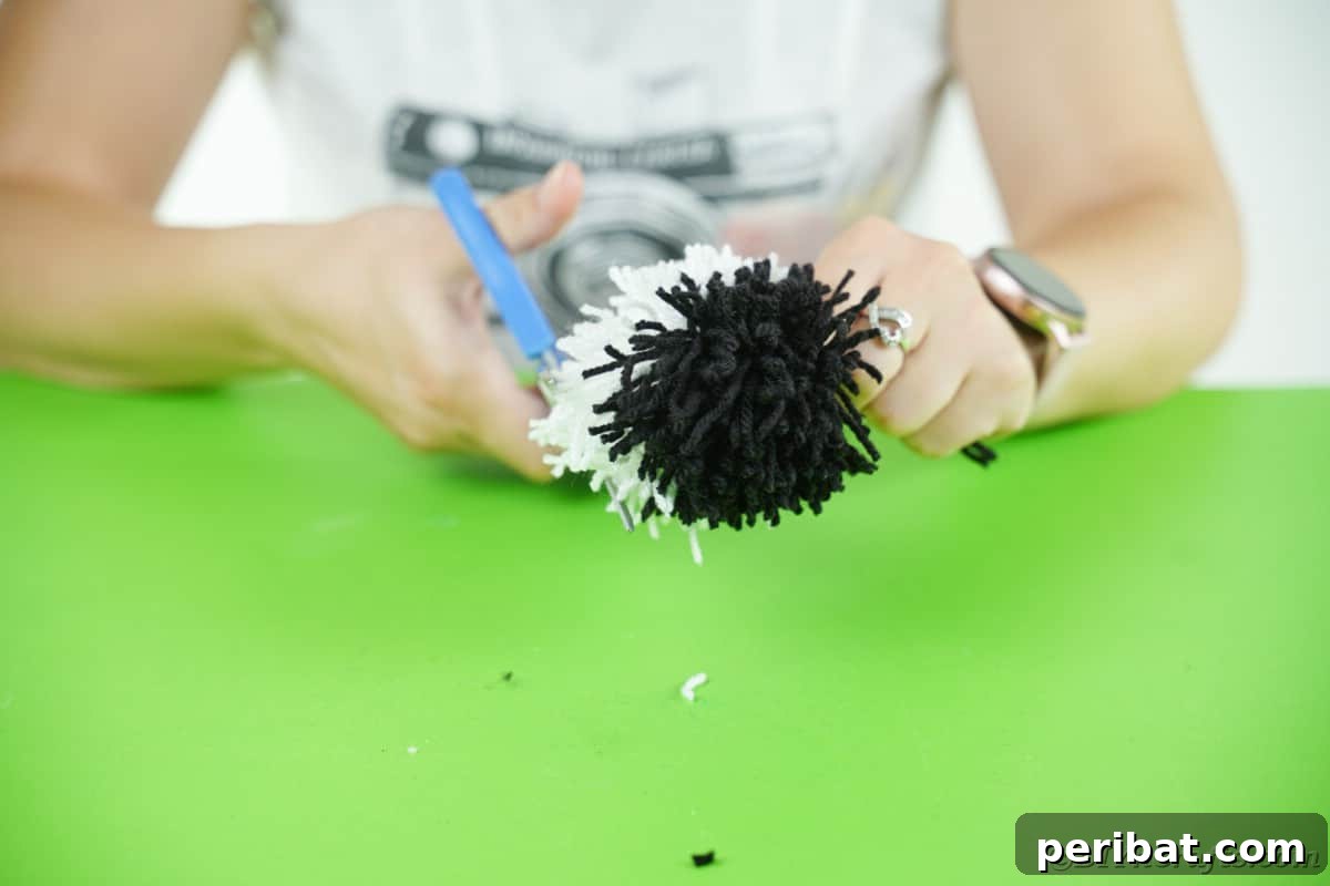 Handmade Pom Pom Penguin Winter Charm 13 Trimming and shaping a pom pom into a round ball