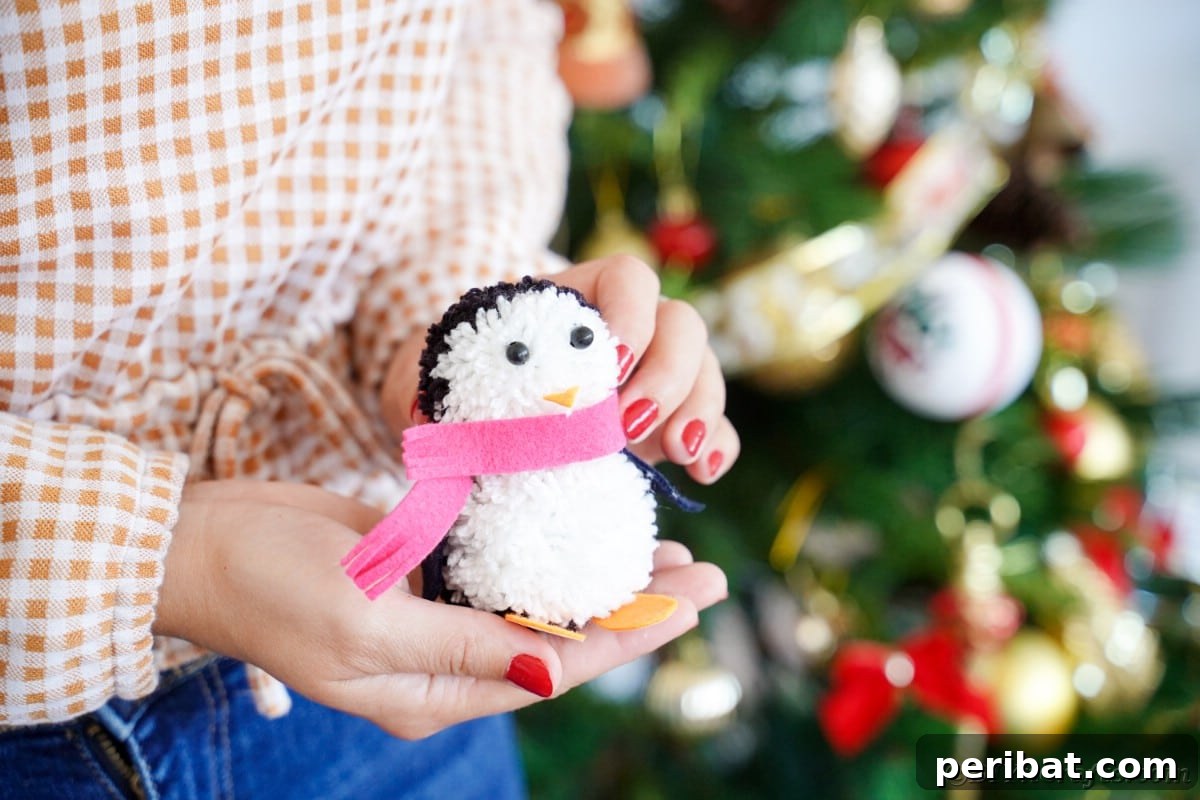 Handmade Pom Pom Penguin Winter Charm 3 Woman proudly holding a finished pom pom penguin craft