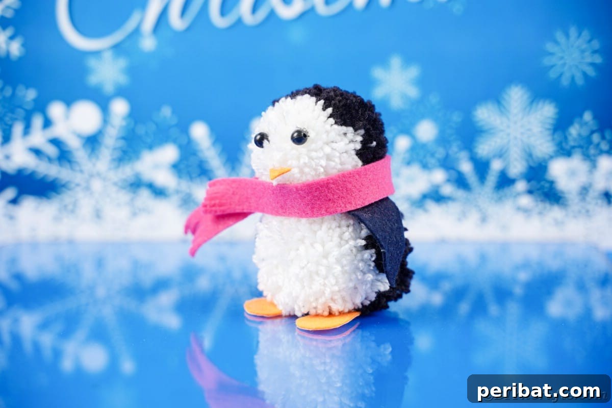 Handmade Pom Pom Penguin Winter Charm 6 Single pom pom penguin on a blue holiday paper background