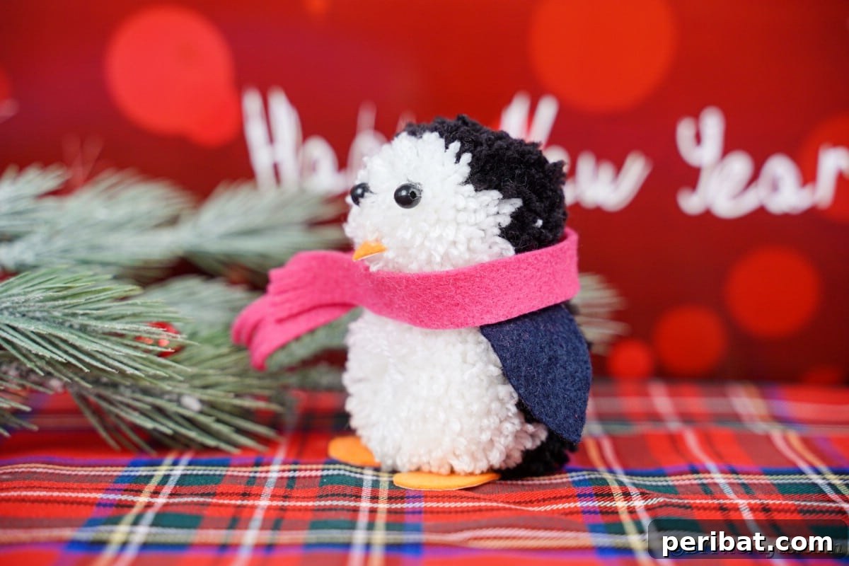 Handmade Pom Pom Penguin Winter Charm 7 Pom pom penguin resting on a flannel blanket
