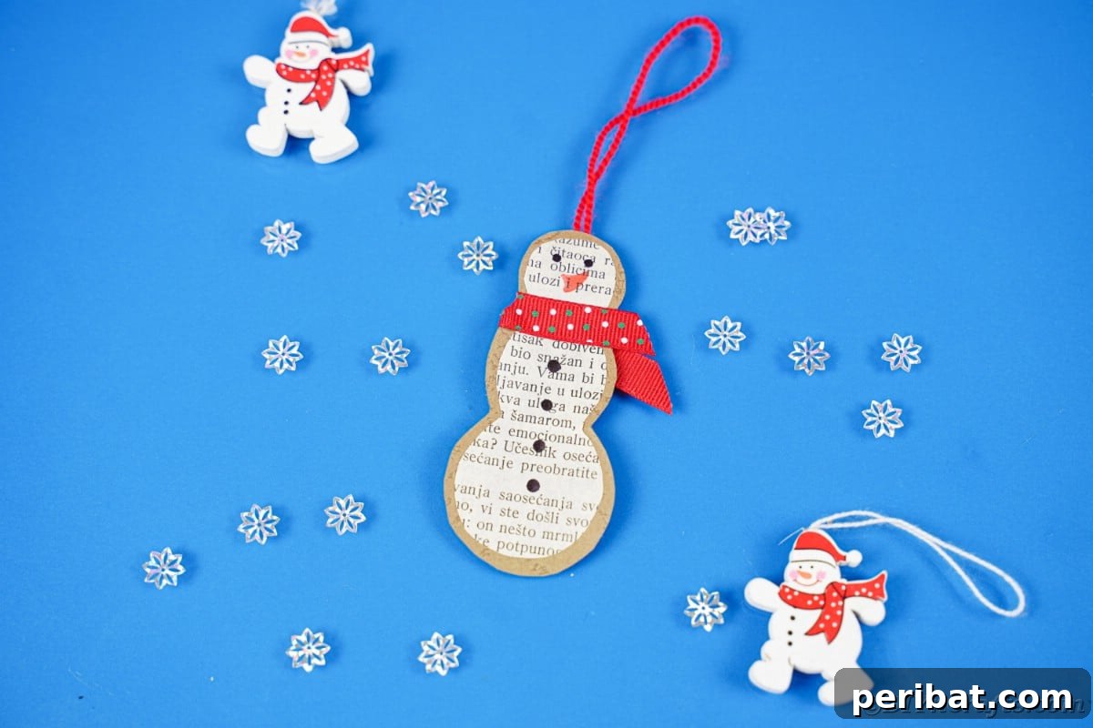 Vintage Book Page Snowman Ornament 4 Rustic snowman ornament made from old book pages on a blue surface