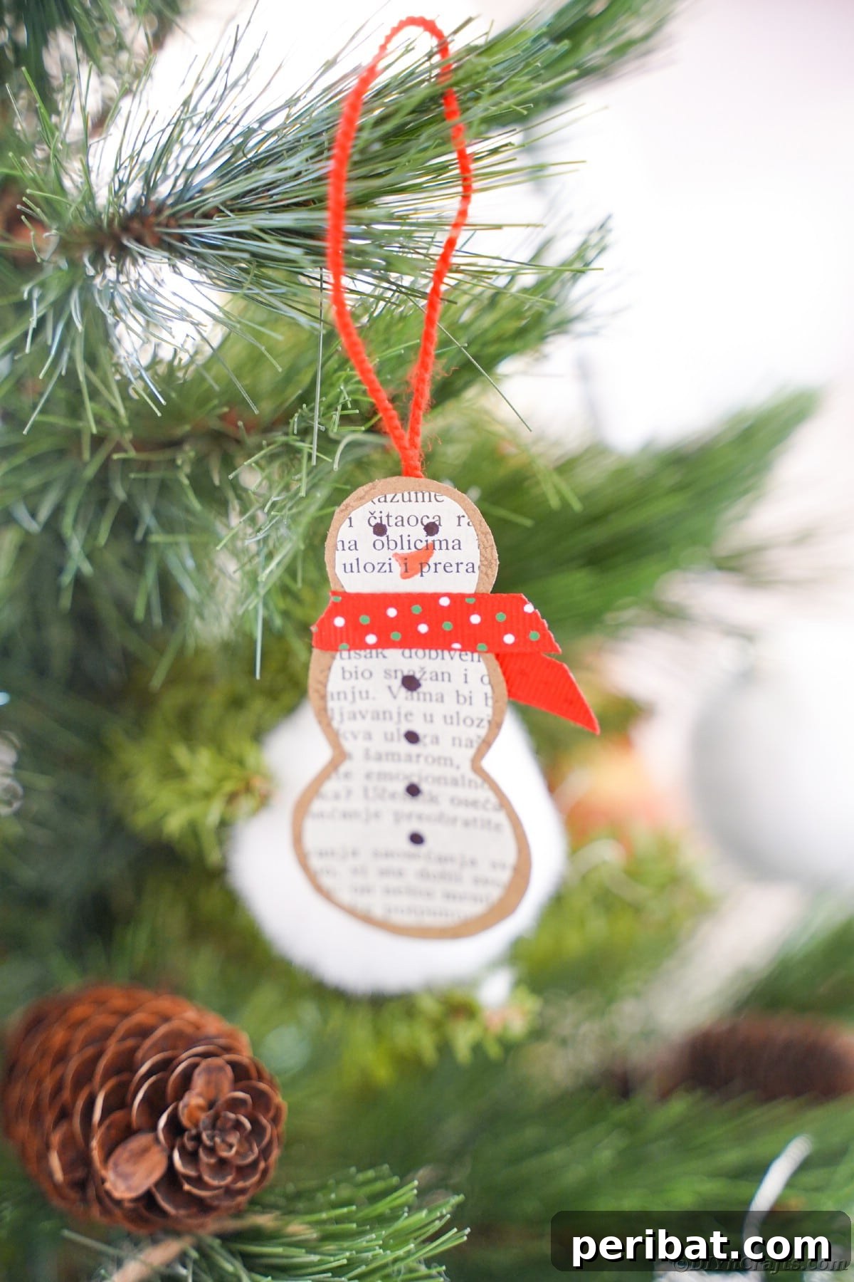Vintage Book Page Snowman Ornament 19 Another view of a handmade paper snowman ornament hanging in a Christmas tree