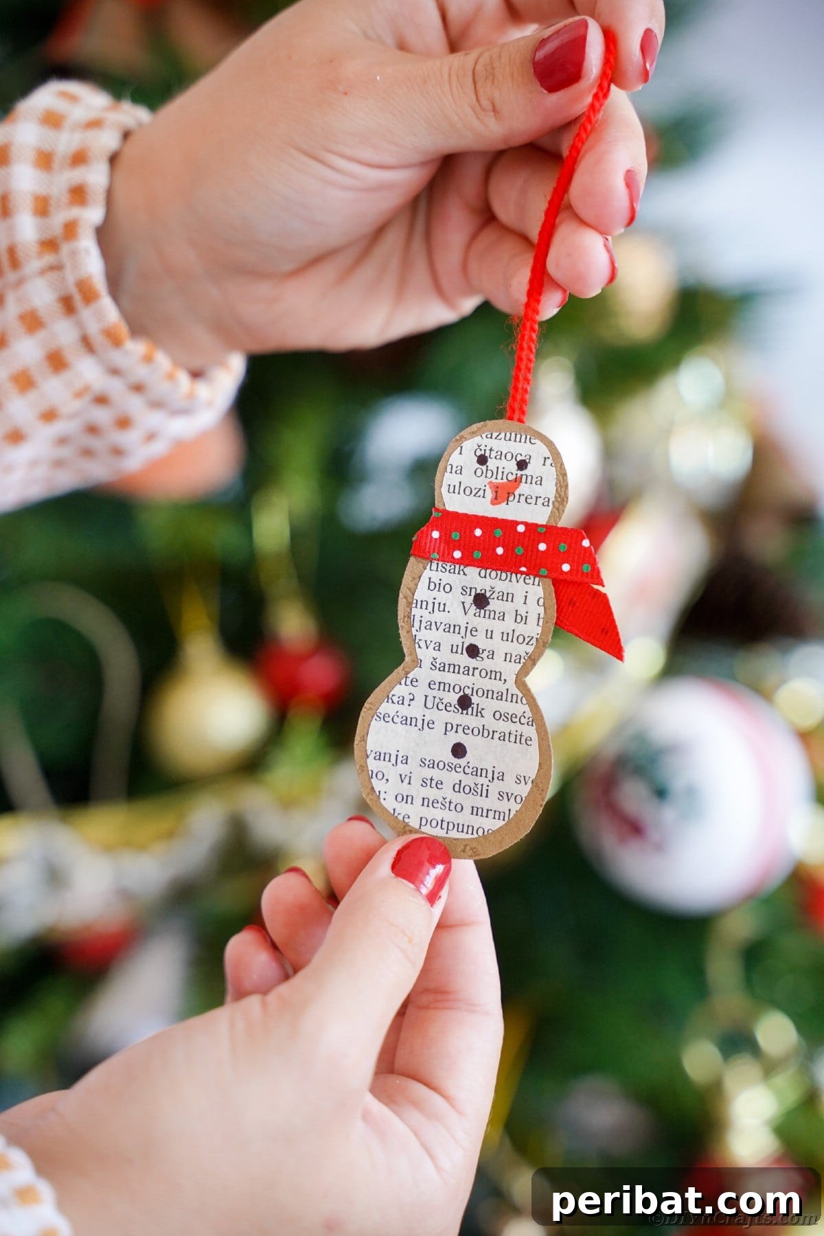 Vintage Book Page Snowman Ornament 20 Person holding a rustic paper snowman ornament made from old book pages