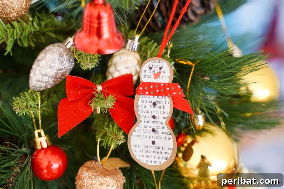 Vintage Book Page Snowman Ornament 6 Close-up of a paper snowman ornament made from old book pages hanging on a Christmas tree