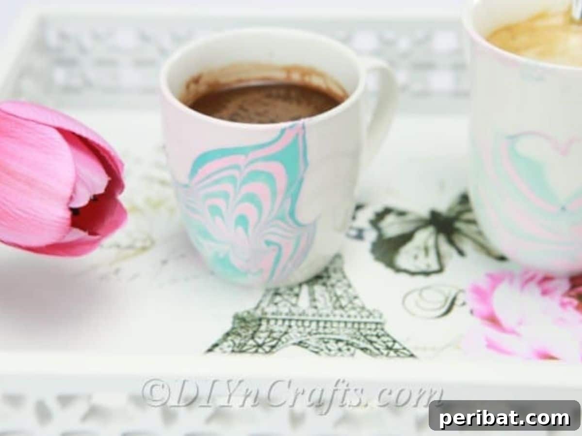 A coffee mug with a beautiful marbled pattern created using nail polish, a fun and creative DIY project.