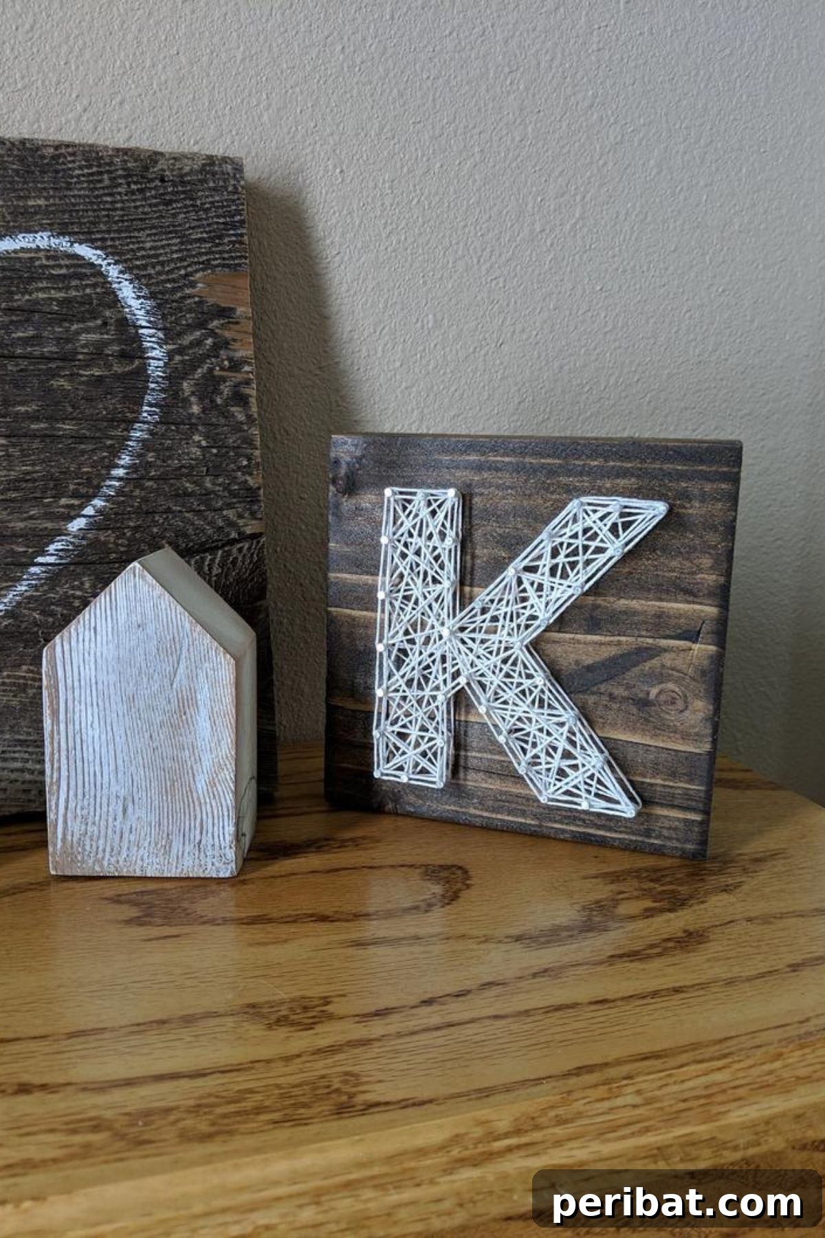 A string art sign featuring the letter 'K' in a modern, artistic style, a unique personalized gift.