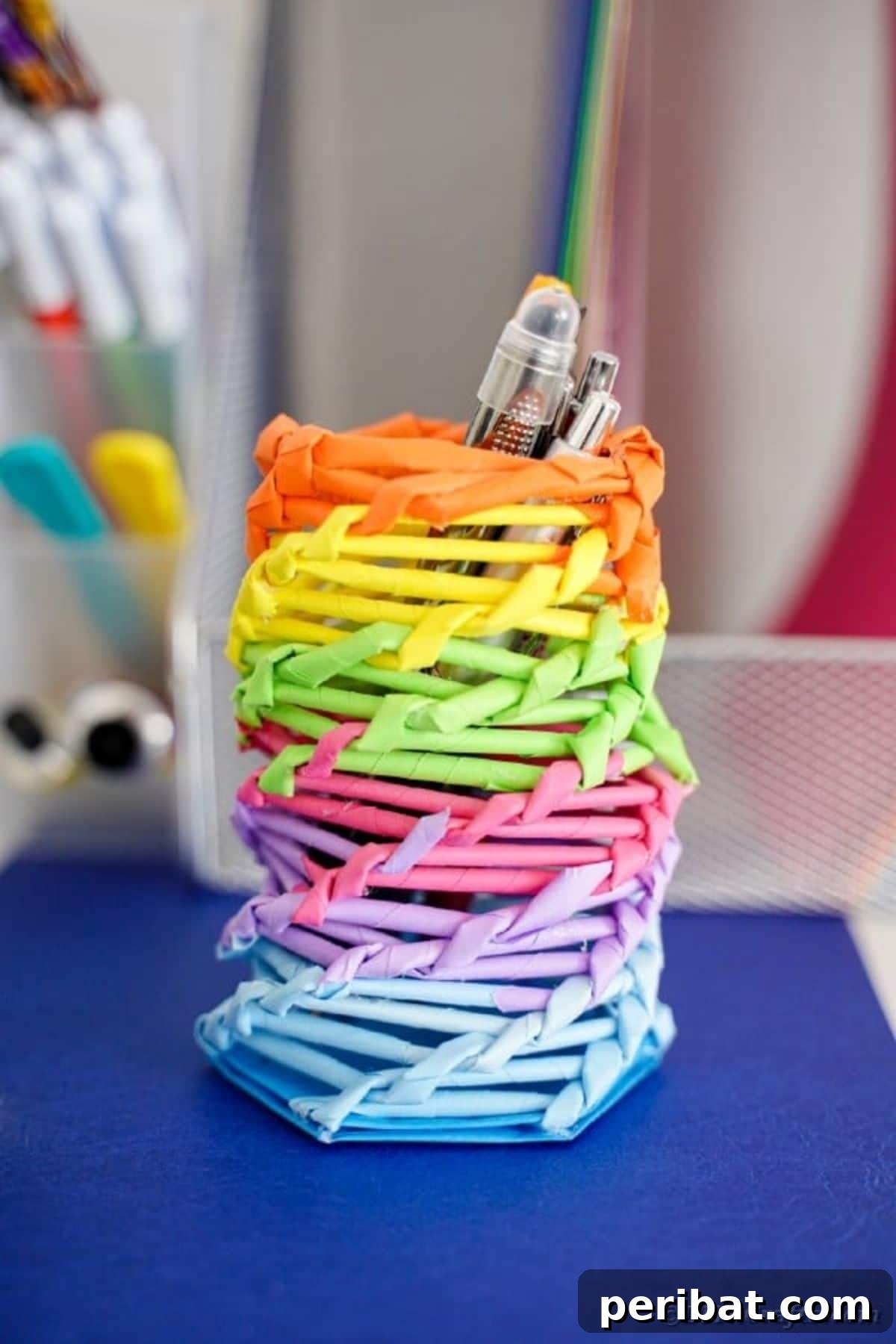 A vibrant rainbow paper straw desk organizer, a colorful and practical DIY gift for kids to store pens, pencils, and art supplies, adding a cheerful touch to their workspace.