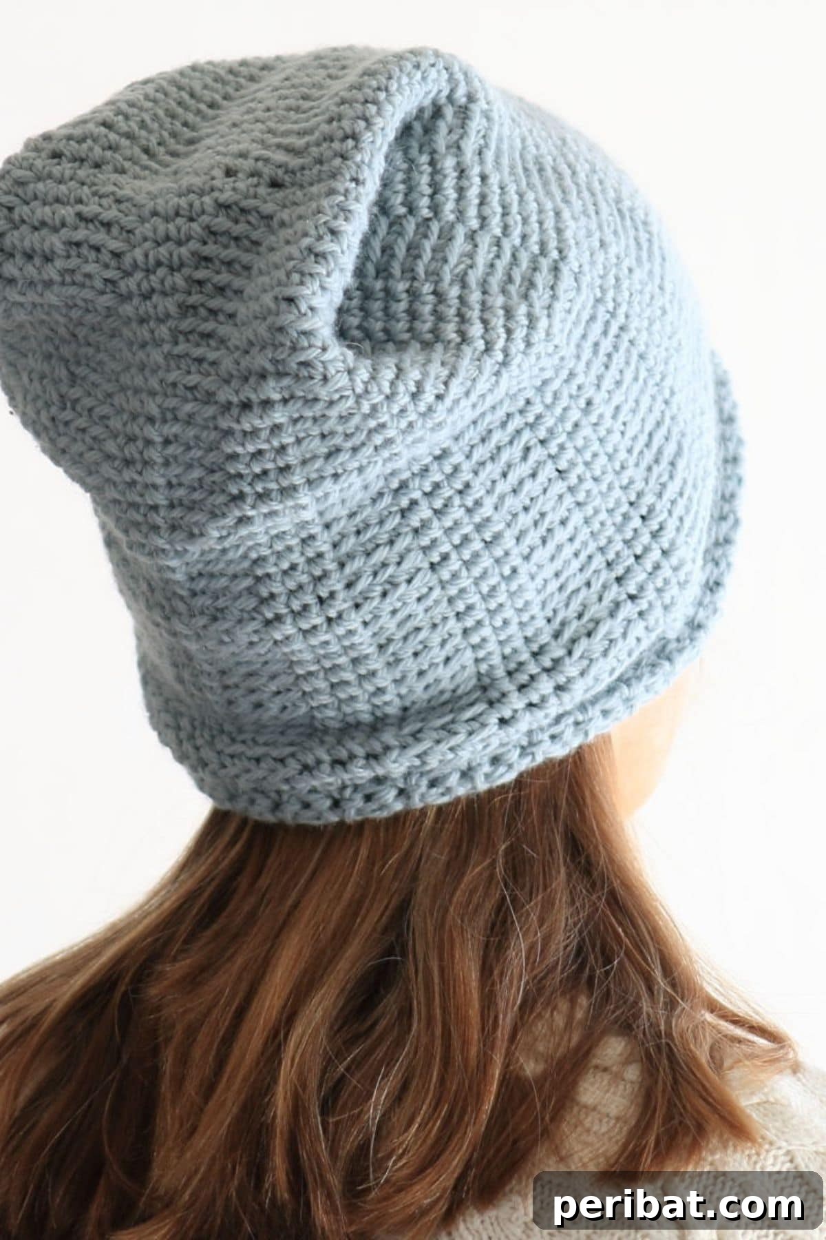 A young girl wearing a stylish Hill Crest crochet hat, demonstrating a warm and fashionable DIY accessory suitable for children of various ages.