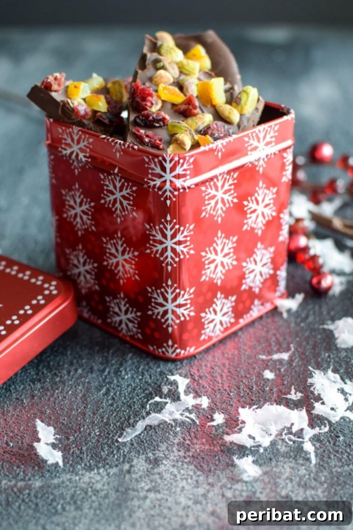 Chocolate bark with candied orange peel in a decorative tin