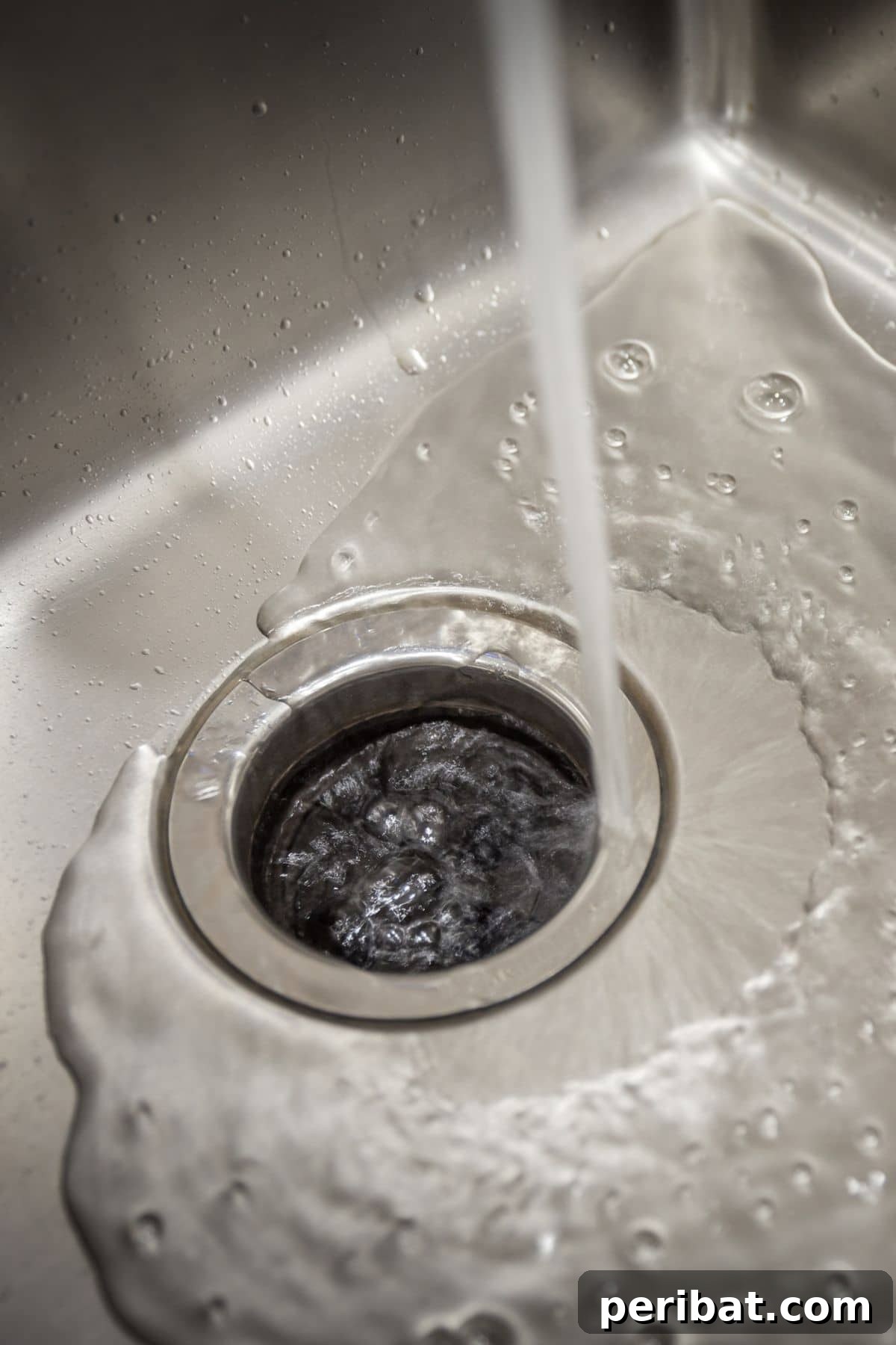 Kitchen sink with water running into the garbage disposal