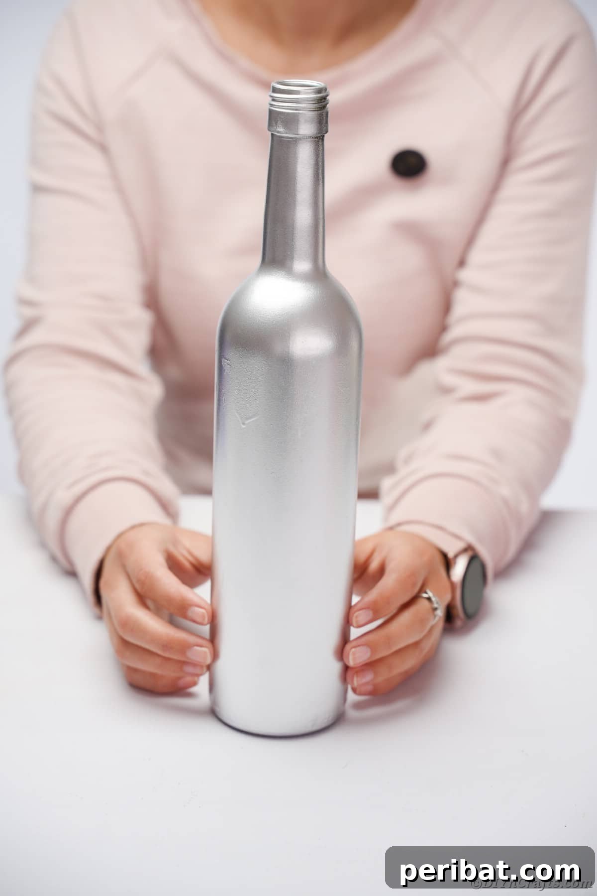 Spraying a wine bottle silver for New Year's Eve decoration.