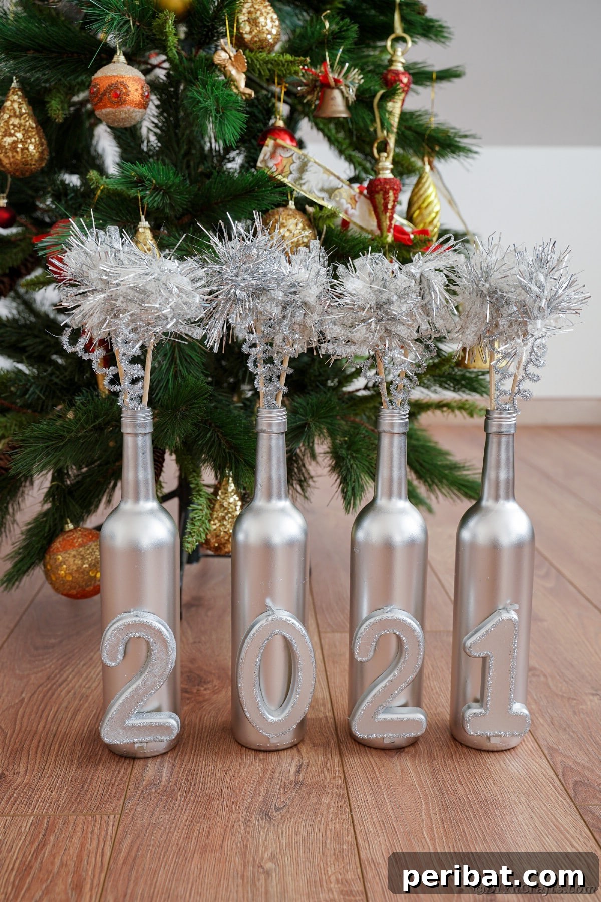 Silver-painted wine bottle decoration with the year numbers, elegantly displayed in front of a subtly blurred Christmas tree.