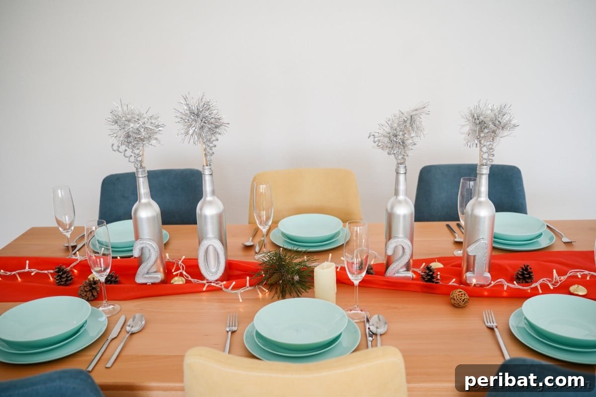 Four silver painted wine bottles with numbers on a table, decorated for New Year's Eve.