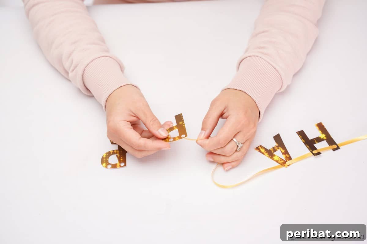 Free Printable Happy New Year Banner Instant 10 Minute Setup 10 Hands carefully stringing gold ribbon through the punched letters to form the Happy New Year banner, demonstrating the assembly process.