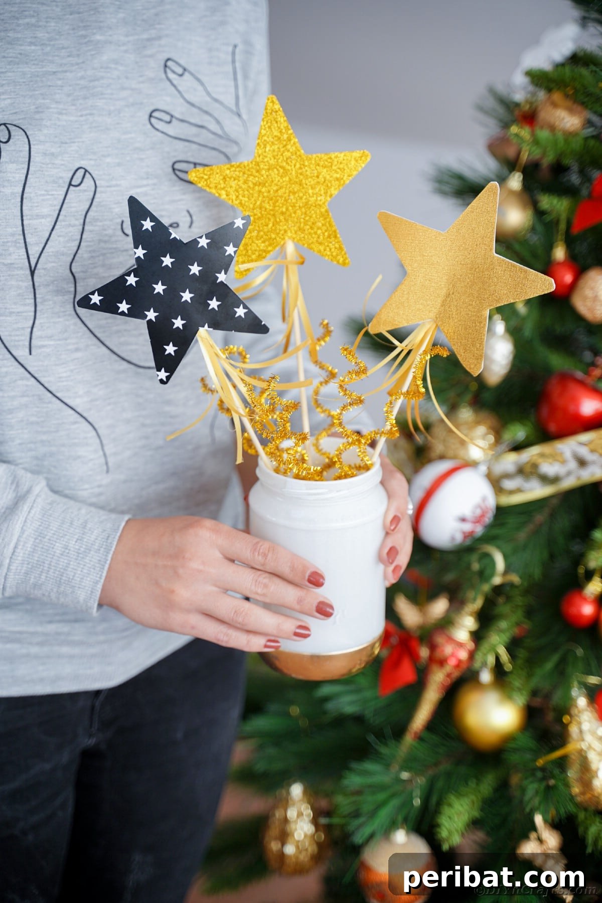 A creator holding a freshly painted mason jar, showcasing the beauty of a DIY upcycling project.