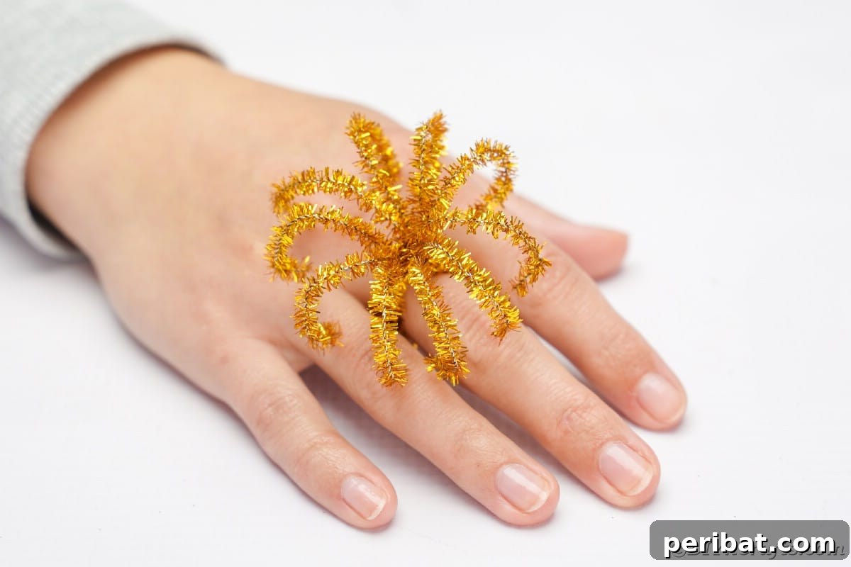 Twist Up a Dazzling Pipe Cleaner Fireworks Ring 4 A finished sparkling pipe cleaner fireworks ring elegantly worn on a woman's hand, showcasing its playful design