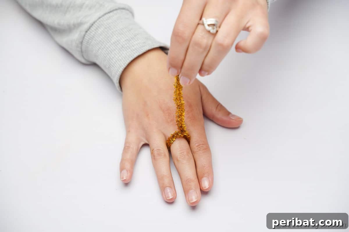 Twist Up a Dazzling Pipe Cleaner Fireworks Ring 9 Close-up view of hands securing the loose ends of a pipe cleaner around the formed ring on a finger