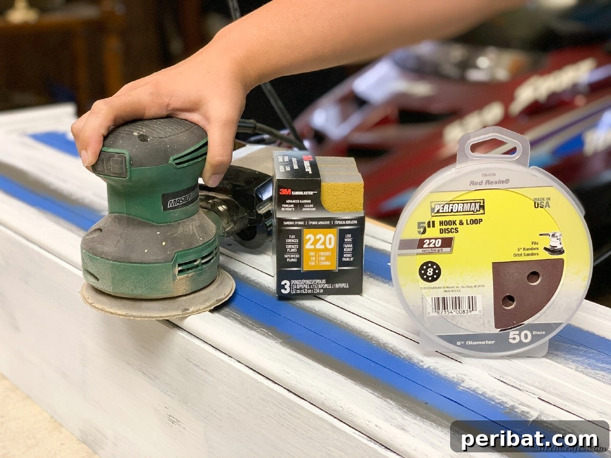 Sanding the curio cabinet to distress the paint