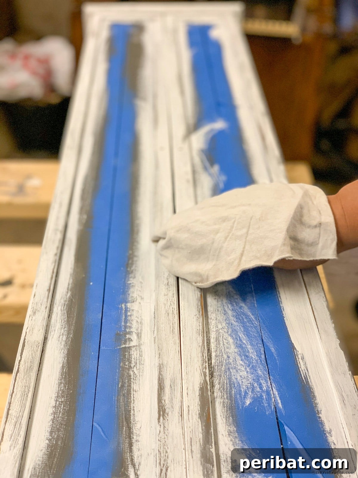 Cleaning dust from the distressed curio cabinet before waxing