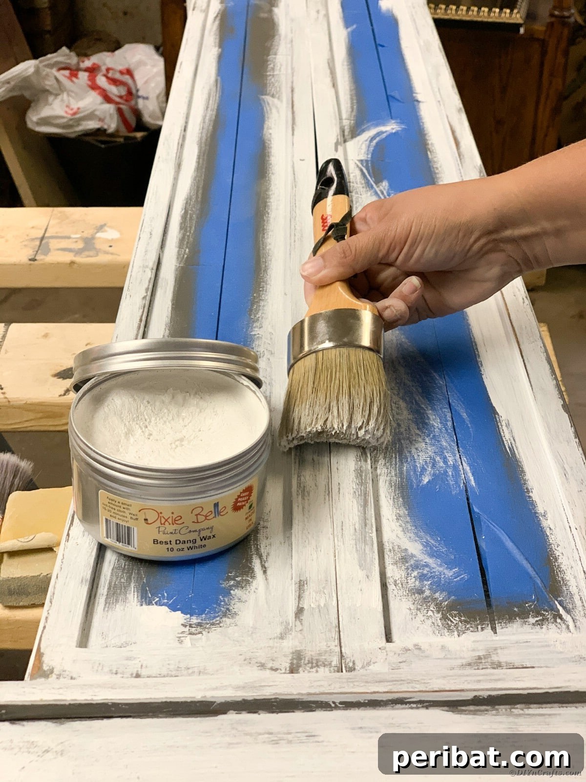 Applying clear wax to the distressed curio cabinet