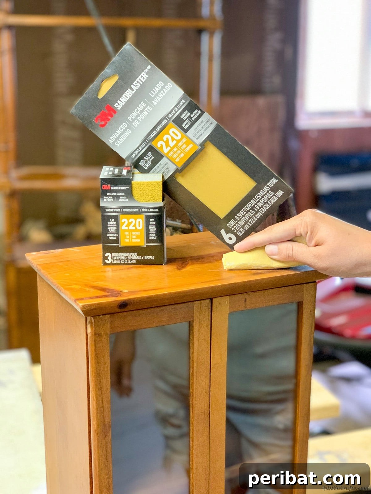 Sanding the curio cabinet to prepare for painting