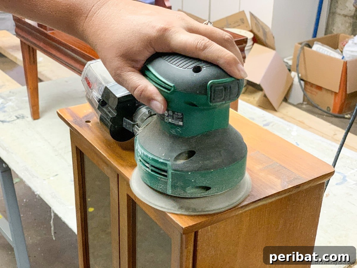 Close-up of sanding a curio cabinet detail
